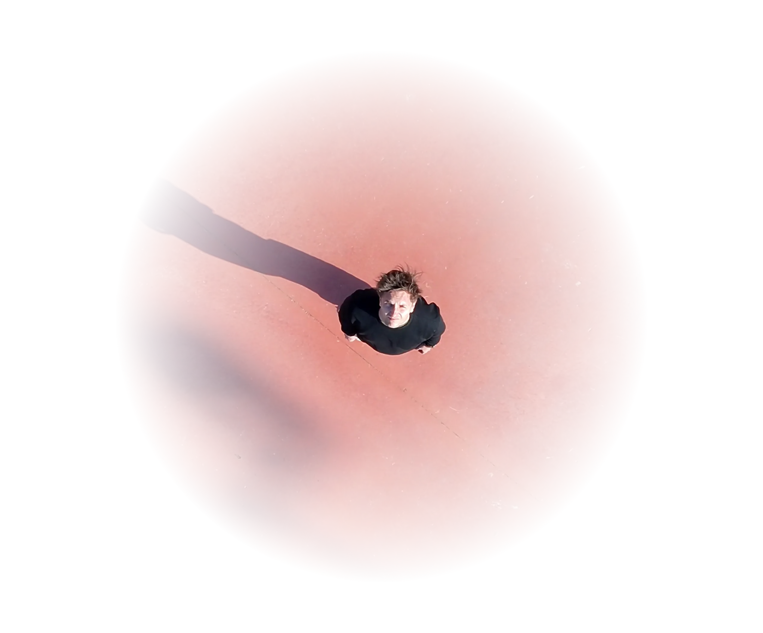 Vue aérienne du sol : Nicolas Fiascaro, longue ombre projetée sur un sol terracotta.